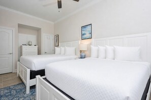 A hotel room with two beds, a dresser, a lamp, and a framed picture on the wall. - Phoenix Gulf Towers 1006 2 Bedroom Condo (Orange Beach)