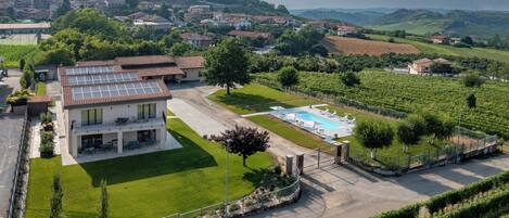 Une villa avec piscine, entourée de vignobles et d’un paysage vallonné.