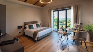 Une chambre moderne avec un grand lit, une table à manger avec des chaises et une vue sur l’extérieur.