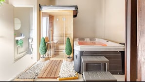 A modern bathroom with a wooden floor, a large bathtub, and a small seating area. - Jaccuzzi Sauna Private Spa Paris (Montrouge)