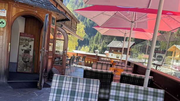 Un restaurant doté d’une terrasse, d’une façade en bois et offrant une vue sur les montagnes.