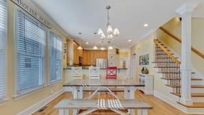 A spacious kitchen with wooden cabinets, a central island, and a dining area with a bench.
