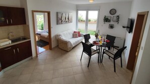 A compact living space with a kitchenette, a dining area, and a sofa. - Apartment Lino with 2 bedrooms (Zadar)