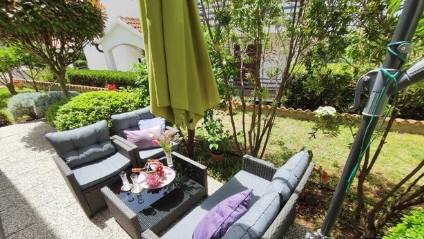 An outdoor seating area with wicker furniture and a table set with drinks and snacks. - Apartment Lino with 2 bedrooms (Zadar)