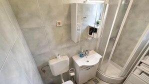 A bathroom with a toilet, sink, and shower. - Apartment Lino with 2 bedrooms (Zadar)