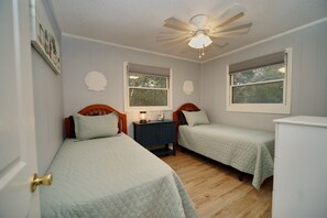 A bedroom with two single beds, a nightstand, a ceiling fan, and two windows. - OS758- 4 Bedrooms, Saltwater Pool & Hot Tub and 2 Spacious living areas (Corolla)