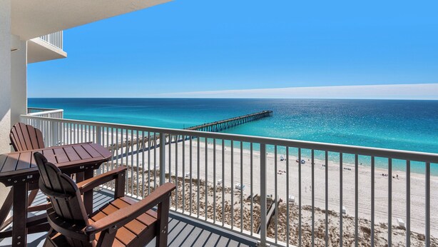 Un balcon avec vue sur une plage et une jetée.