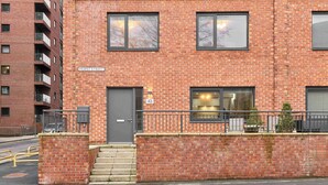 A red brick building with a grey door, a window with a view, and a sign reading "HURST STREET". - Host & Stay | Chic Townhouse by the Docks (Liverpool)