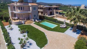 A multi-story house with a swimming pool, outdoor seating, and a landscaped garden. - Villa Amare - Heraklion Private Pool & Garden Gem (Kato Gouves)