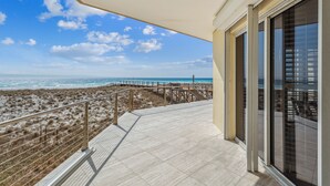 Un balcon avec vue sur la plage et l’océan.
