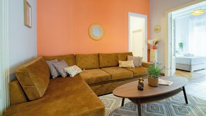 Una sala de estar con un sofá modular, una mesa de centro redonda y una planta en maceta.