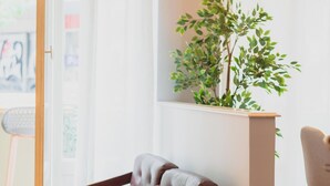 Una sala de estar moderna con un sofá de cuero, una mesa de centro de madera y una planta en maceta.