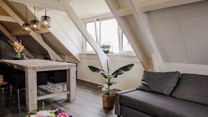 A modern loft with a dining area, a sofa, and a potted plant. - Cozy apartment in center of Yerseke (Yerseke)