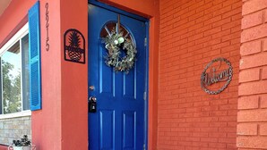 A blue door with a wreath, a welcome sign, and a mailbox. - Charming 2-bedroom house in beautiful Port Charlotte with Pool, Hot tub, & WiFi (Port Charlotte)