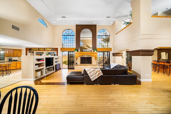 A spacious living area with a fireplace, a sofa, and a kitchen area with a bar. - 20% Off May WkDays! Perfect For Families Pool, Spa (Temecula)