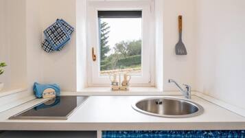 Een koelkast, kookgerei, borden en bestek