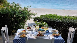 A table set for a meal with a view of the sea and mountains in the background. - Blue Bay Beach Resort (Rhodes)