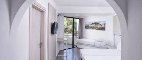 A modern hotel room with a large arched doorway, a bed, a desk, and a TV.