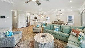 A spacious living room with a green sofa, a round coffee table, and a ceiling fan. - Lost Key Villas Golf & Beach Club ~Stillwater -  NO HASSLE CHECK OUT (Perdido Key)