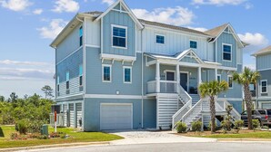 A two-story house with a front porch, a garage, and a staircase leading to the second floor. - Lost Key Villas Golf & Beach Club ~Stillwater -  NO HASSLE CHECK OUT (Perdido Key)