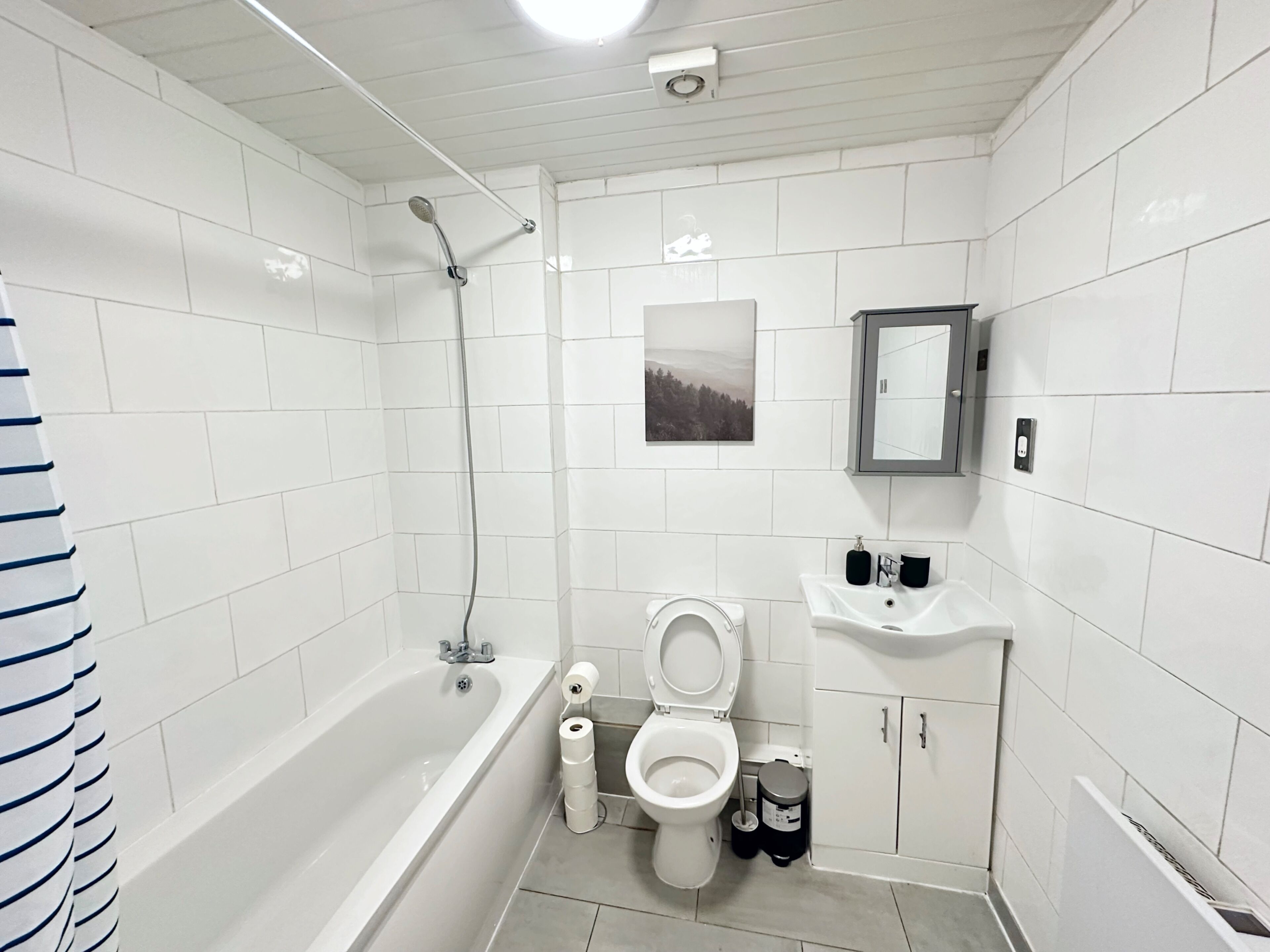 A modern bathroom with a bathtub, toilet, and sink.