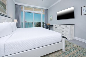 Habitación de hotel con una cama grande, un televisor de pantalla plana, un escritorio y vista al cielo.