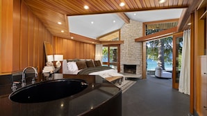 Un baño moderno con un lavamanos negro grande, paneles de madera y una chimenea de piedra.
