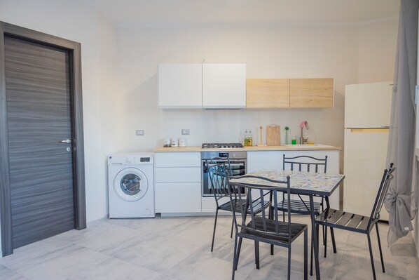 Een oven, een kookplaat, kookgerei, borden en bestek