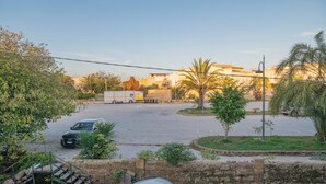A parking lot with a few cars, a small staircase, and a stone wall. - New apartment 3 minutes from the archaeological park and 600 meters from the sea (Marinella)