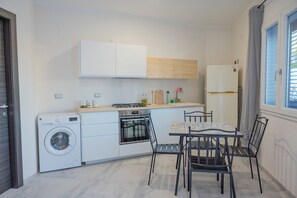 Een oven, een kookplaat, kookgerei, borden en bestek