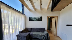 Un salon moderne avec un canapé, une table basse ronde et un tableau accroché au mur.
