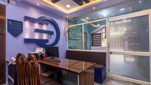 A modern office with a wooden desk, a computer, and a large clock on the wall.