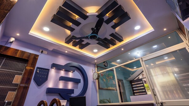 A modern interior with a ceiling fan, recessed lighting, a large clock, and a world map.