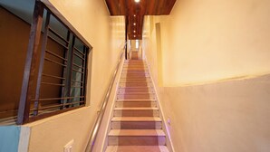 A staircase with a wooden ceiling and a metal railing, leading to an upper floor.