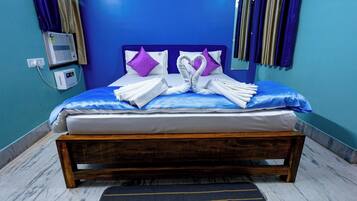 A neatly made bed with a wooden frame, a blue headboard, and purple pillows.