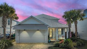 A single-story house with a garage, a front porch, and a small garden with palm trees and shrubs. - 💙Walk 2 Beach-Community Pool-4BR Sand Dollar Beach Cottage🌊 (Miramar Beach)