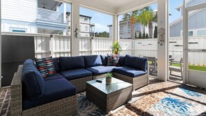 A covered patio area with a sectional sofa, a coffee table, and a potted plant. - 💙Walk 2 Beach-Community Pool-4BR Sand Dollar Beach Cottage🌊 (Miramar Beach)