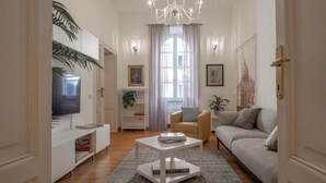 A living room with a sofa, a coffee table, a TV, and a bookshelf. - NICALANDRO HOUSE - ROME CENTER (Roma)