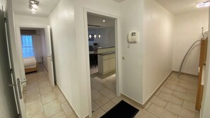 A hotel room with a bed, a small desk, a bathroom with a shower, and a kitchen area. - Apartment Near Marina Nieuwpoort & Golf (Nieuwpoort)