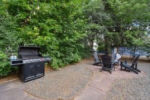 An outdoor patio with a grill, seating area, and string lights. - The Rams' Den – King Beds, Fire Pit, Spacious Yard (Fort Collins)