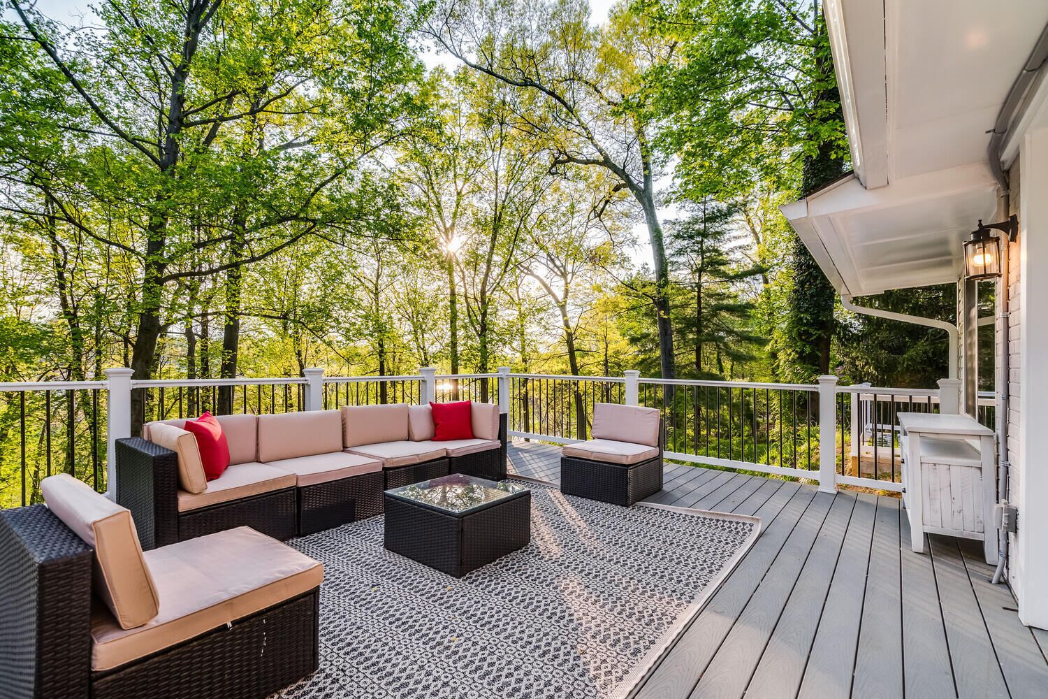 A deck with outdoor furniture, including a sofa and chairs, and a small table.