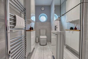 A modern bathroom with a toilet, sink, and towel rack. - Stunning 6 bed in Nottingham - Sleeps 16 (Nottingham)