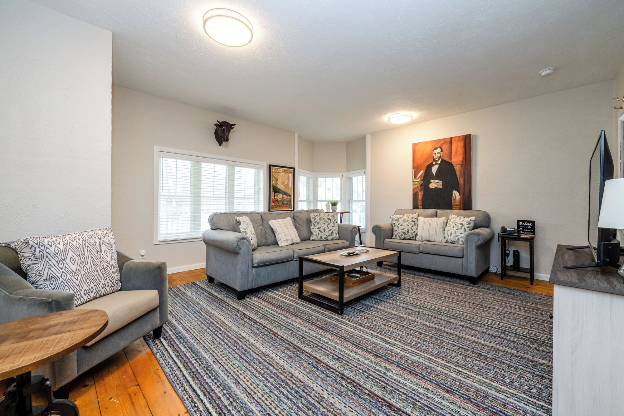 A living room with two grey sofas, a coffee table, and a patterned rug.