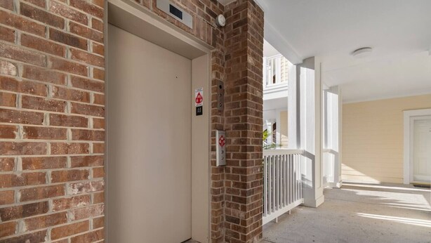 A residential building with a brick exterior, a white door, and a balcony with a white railing. - Water Views- 5 Beds- Near Broadway @ Beach- Pools (Myrtle Beach)