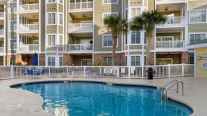 A swimming pool with a white fence, lounge chairs, and a sign indicating no lifeguard on duty. - Water Views- 5 Beds- Near Broadway @ Beach- Pools (Myrtle Beach)