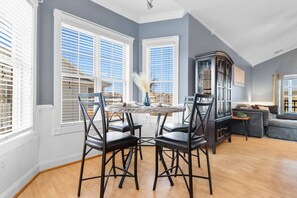 A spacious living room with a dining area, large windows, and a built-in cabinet.