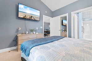 A bedroom with a bed, a dresser, a TV on the wall, and an open door leading to another room. - Water Views- 5 Beds- Near Broadway @ Beach- Pools (Myrtle Beach)