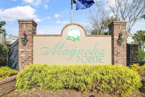 Un cancello d'ingresso in mattoni con il nome 'Magnolia Pointe' e un logo sopra.