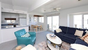 Ein moderner Wohnraum mit Küche, Essbereich und einer Sitzecke mit Sofa und Couchtisch.