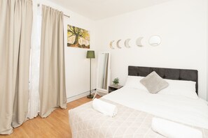 2 habitaciones, escritorio y tabla de planchar con plancha